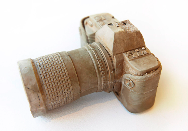 Photo of an SLR camera which appears to be made from compressed dirt or stone.